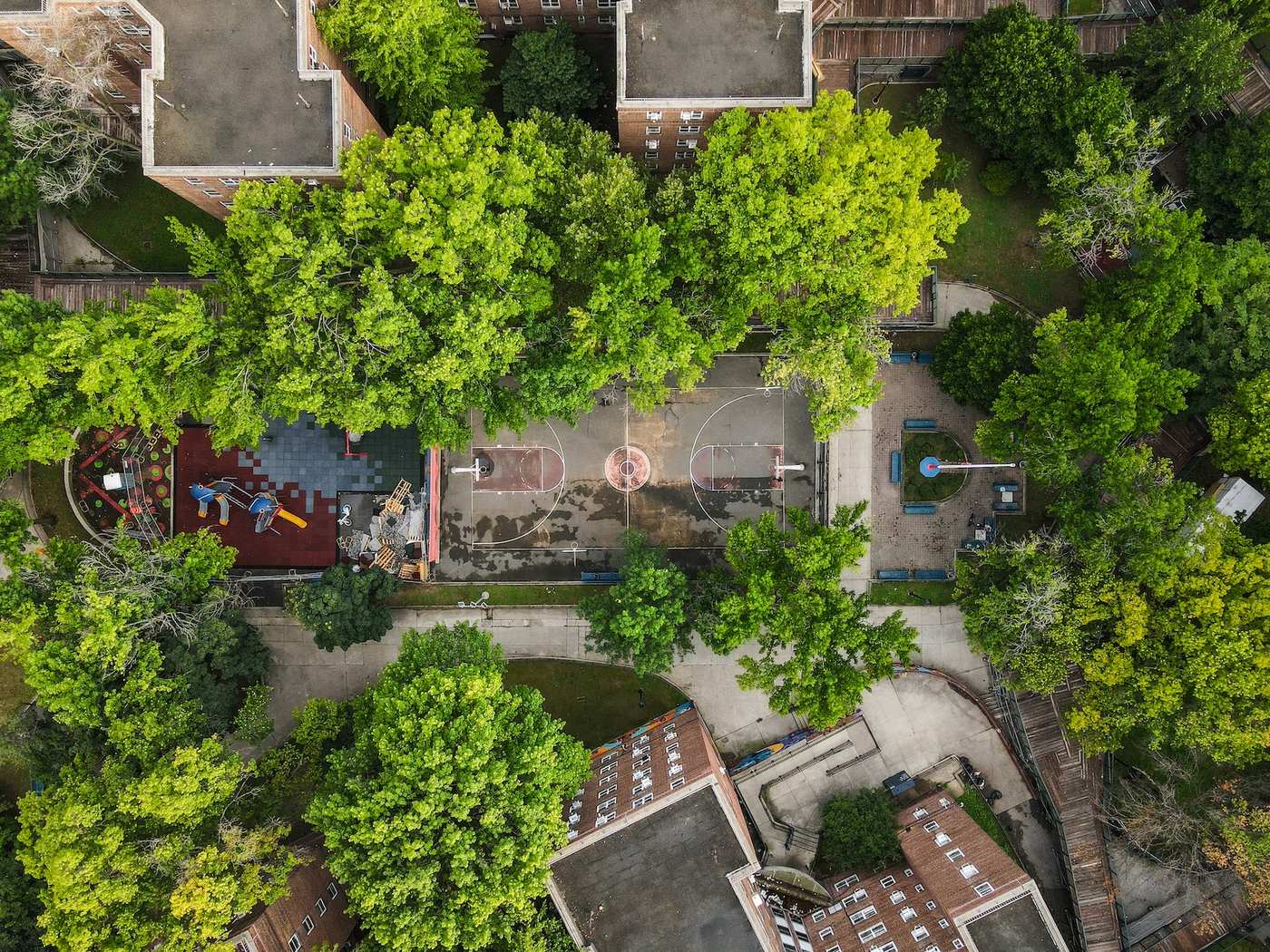 Patterson Houses basketball court before restoration, worn and faded